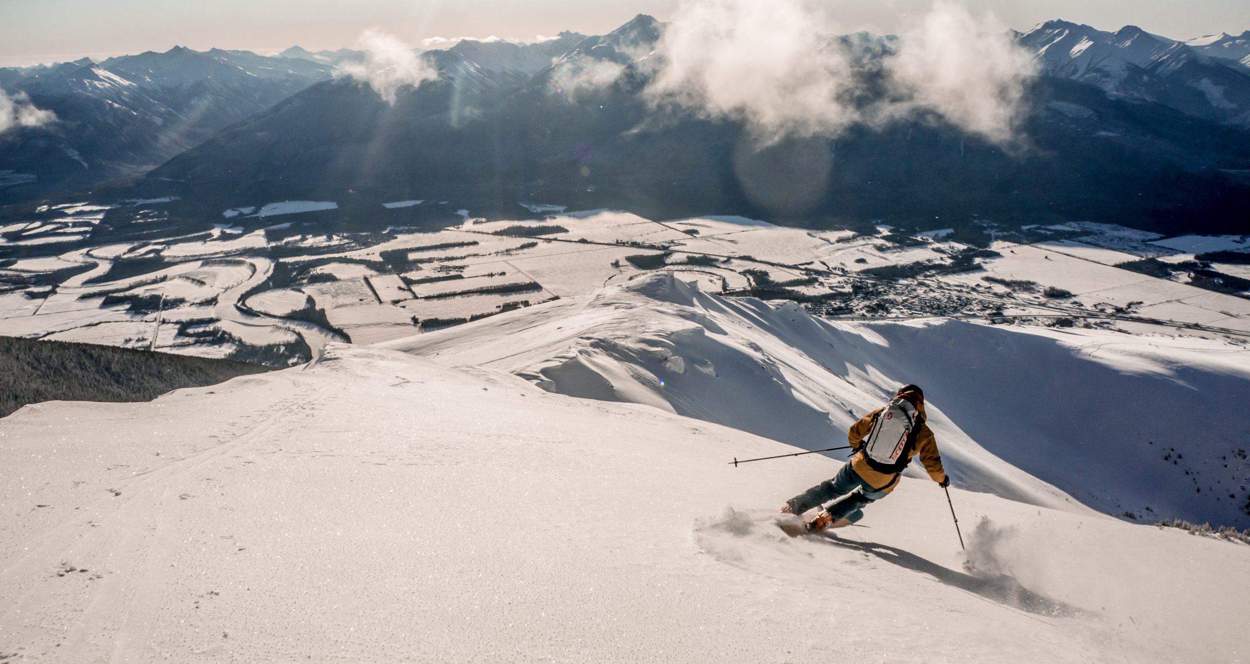 A person skiing down a snowy peak in McBride