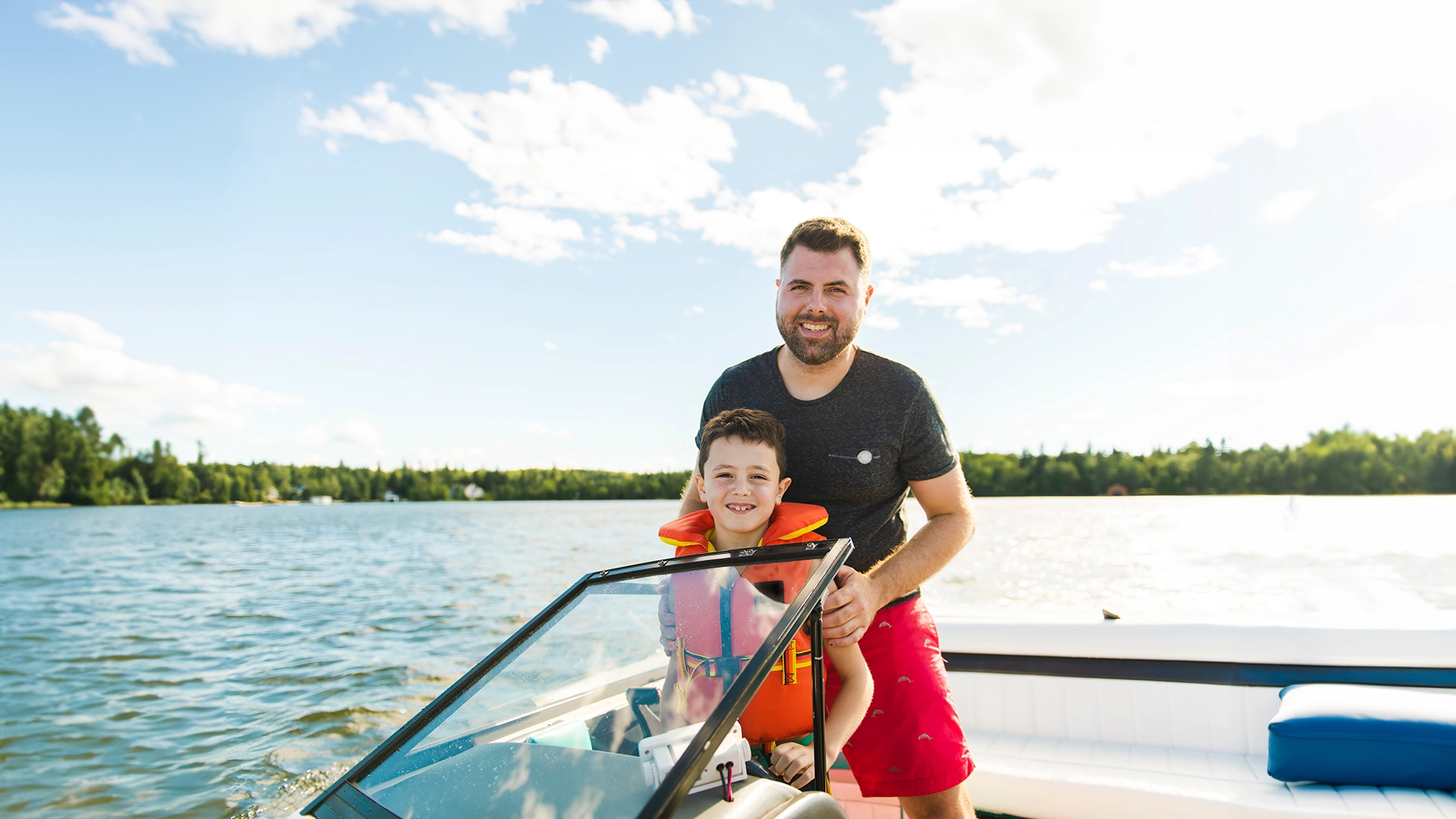 A kid and adult smiling on a boat